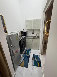 a small kitchen with a stove and a refrigerator at Lightmoon studio Jimi in Al Ain