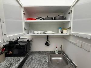 a small kitchen with a sink and a microwave at Lightmoon studio Jimi in Al Ain