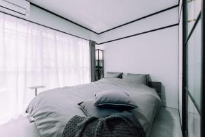 a bedroom with a large bed with pillows on it at Work Ready Stay - Quiet Nakasu 202 in Fukuoka