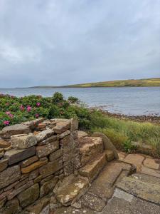 a stone wall next to a body of water at The Mill O Cara in Orkney