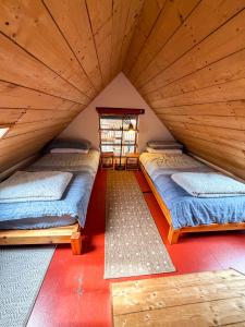 two beds in a room with wooden ceilings at The Mill O Cara in Orkney