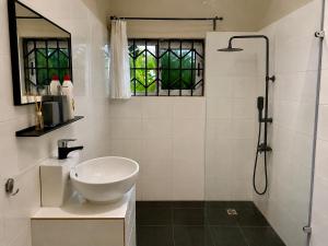 a white bathroom with a sink and a shower at Lukas Garden Accra Exclusive Resort in Accra +75 photos
