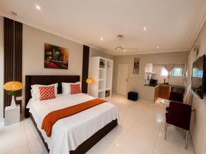 a bedroom with a large bed and a kitchen at Lukas Garden Accra Exclusive Resort in Accra