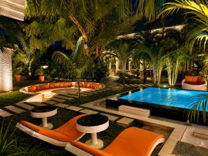 a swimming pool with orange chairs and a swimming poolvisor at Lukas Garden Accra Exclusive Resort in Accra