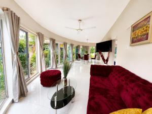 a living room with a red couch and large windows at Lukas Garden Accra Exclusive Resort in Accra