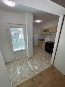 an empty room with a kitchen and a large window at Casa Regina in Crno