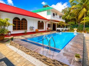 a swimming pool in front of a house at Ocean villa in Hiriketiya