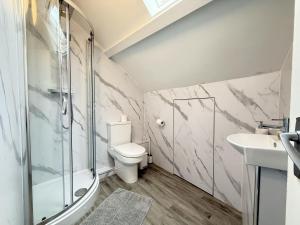a bathroom with a shower and a toilet and a sink at Crows Nest - panoramic views of St Ives harbour in St Ives +17 photos
