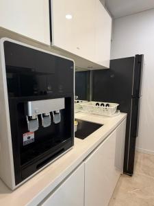 a kitchen with a black and white microwave at VORTEX SUITES KLCC By SKYLINE in Kuala Lumpur