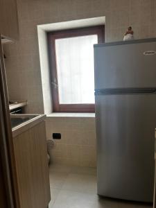 a kitchen with a refrigerator and a window at B&b La Casa di Michela in Castelmezzano +1 photo