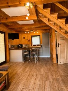 a kitchen and living room with a table in a cabin at Domek Pod Tylką in Grywałd