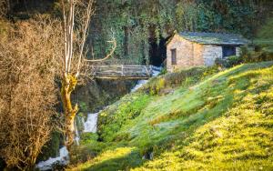 a house on a hill with a bridge over a stream at Casa de Aira Padron 