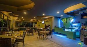 a restaurant with tables and chairs and people in it at Apple Tree Resort & Hotel in Opol