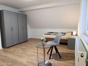 a bedroom with a bed and a glass table and a chair at Landhaus Leopold in Sanitz