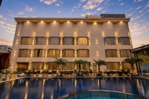 a building with a swimming pool in front of it at The Aura Hotel & Resort in Noida