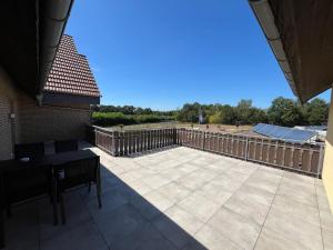 eine Terrasse mit einem Holzzaun und einem Tisch in der Unterkunft Seeterrasse in Versmold