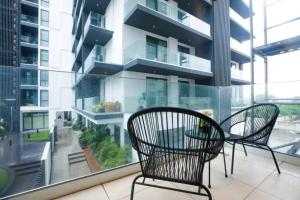 a balcony with two chairs and a table in a building at Nova, Sky Suites in Accra