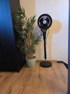 a black fan sitting on a wooden floor next to a plant at Modern Western - Apartment Blue in Eging