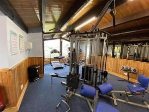 a gym with several tread machines and blue chairs at 3-Bed Caravan Sleeps 7 with Indoor Pool in Wigton