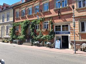 a building with tables and chairs on a city street at Zum Schinderhannes in Waibstadt