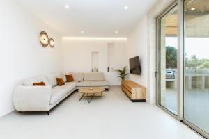 a living room with a couch and a table at Sky And Stone Private Villa in Kathiana