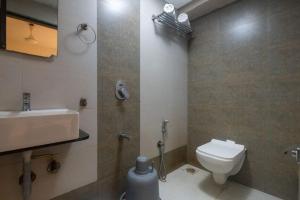 a bathroom with a white toilet and a sink at Hotel Avion Park Executive in Mumbai