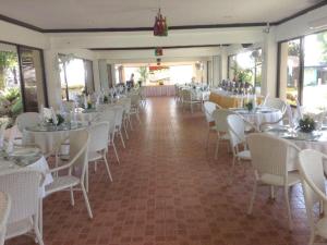 a banquet hall with white tables and white chairs at Jamont Hotel in Sipalay