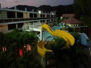 a yellow slide in a resort with a pool at Splash Oasis Resort & Hotel in Forestry