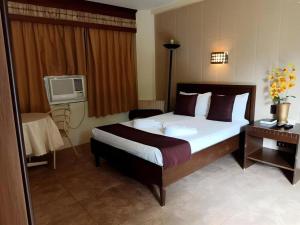 a hotel room with a large bed and a table at Splash Oasis Resort & Hotel in Forestry
