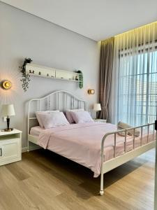 a bedroom with a large bed with pink sheets at Lioravilla15 Kota Baru Parahyangan in Padalarang +14 photos