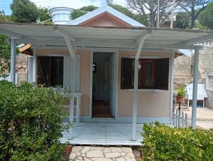 a small house with a porch and a door at Castel bungalow in Palafolls