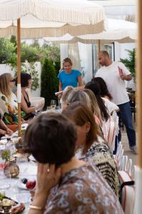 a group of people sitting at tables under an umbrella at Villa Dorothea in Lisbon