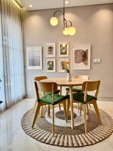 a dining room with a wooden table and chairs at Lioravilla15 Kota Baru Parahyangan in Padalarang