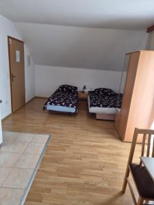two beds in a room with wooden floors at Apartments Dale in Plitvička Jezera