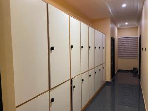 a locker room with white cabinets and a hallway at Anaviosi Villa in Anum