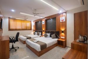 a hotel room with two beds and a desk at Hotel Avion Park Executive in Mumbai