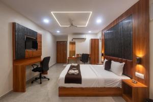 a bedroom with a bed and a desk and a television at Hotel Avion Park Executive in Mumbai +49 photos