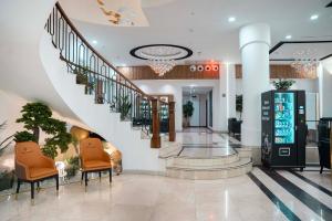 a lobby with stairs and chairs in a building at Wlat Hotel in Erbil +91 photos
