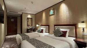 a hotel room with two beds in a room at Macau Masters Hotel in Macau