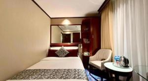 una habitación de hotel con una cama y una silla en Macau Masters Hotel, en Macau