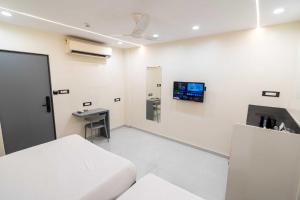 a hospital room with a bed and a tv on the wall at Lake Bloom Residency in Mumbai