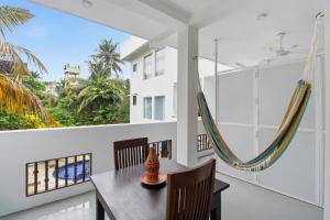 a dining room with a table and chairs and a hammock at Mihira Gedara Apartments in Unawatuna