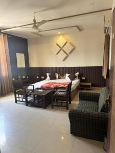 a bedroom with a bed and a table and chairs at Hotel Corbett Inn in Rudrapur