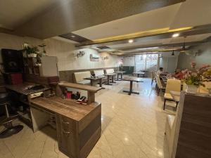 a restaurant with tables and chairs and people in a room at Hotel Corbett Inn in Rudrapur