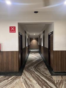 a corridor of a building with wooden doors at Hotel Corbett Inn in Rudrapur +1 photo
