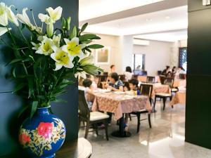 a vase of flowers in a restaurant with children sitting at tables at E Moon Hotel in Taichung
