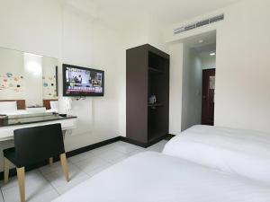 a bedroom with a bed and a desk and a television at E Moon Hotel in Taichung