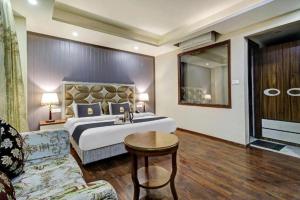 a hotel room with a bed and a couch at Saffron by Stay Pattern - City Center in Srinagar