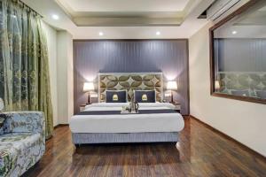 a bedroom with a large bed and a couch at Saffron by Stay Pattern - City Center in Srinagar +4 photos