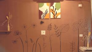 a wall with a mural of plants on it at Hotel Simba by Hakuna in Arambol